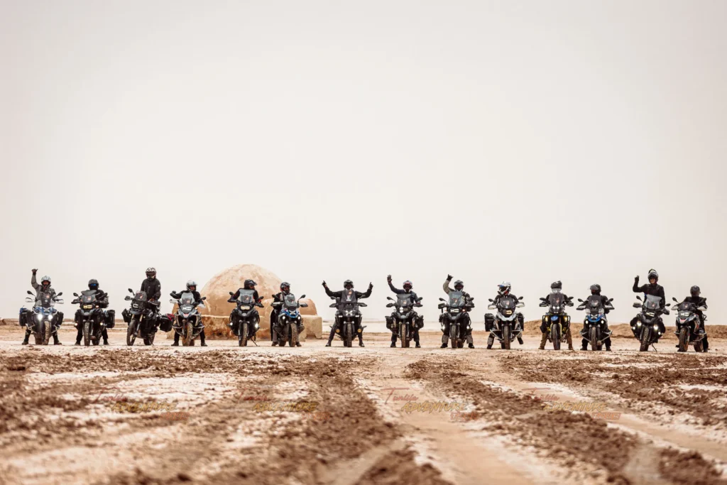 Grand groupe de motards réuni dans le désert pour le Tunisia Adventure Tour