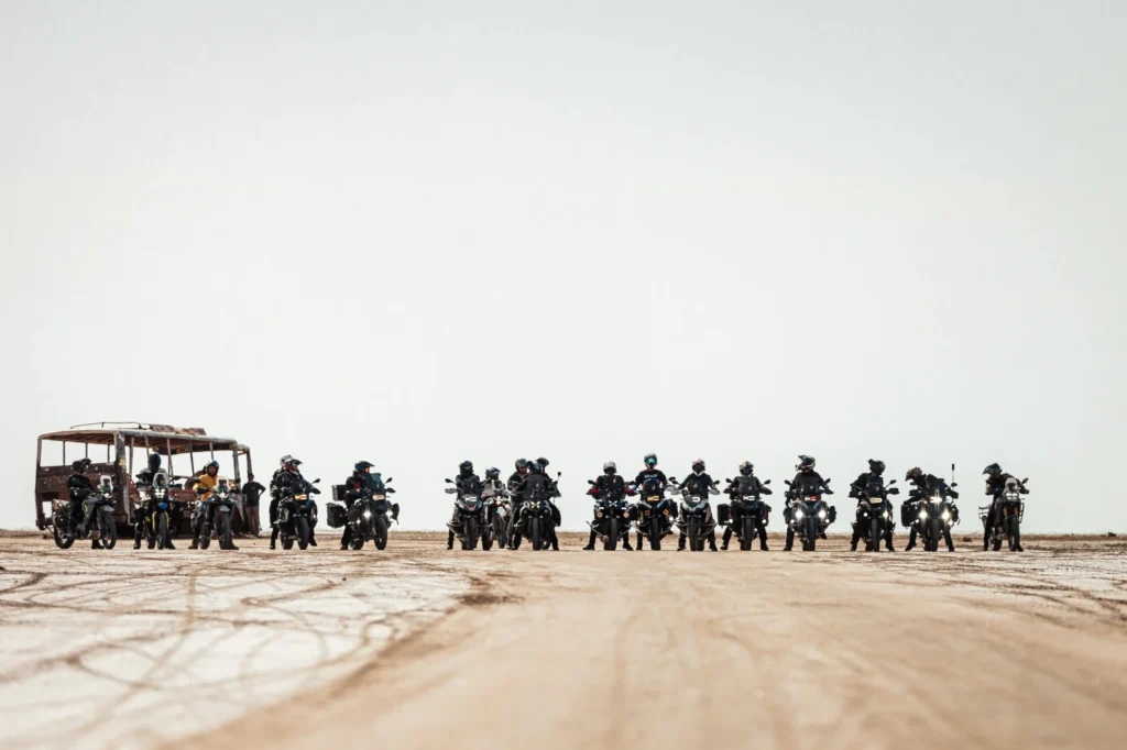 Groupe de motards aligné sur une vaste étendue désertique